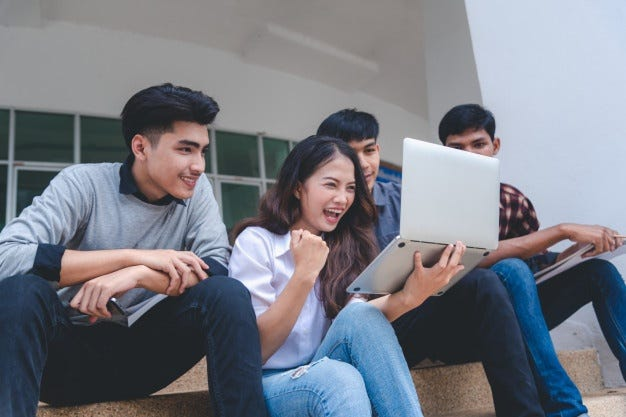 PCの前でガッツポーズする学生たち